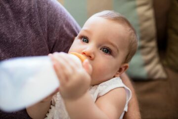 baby met reflux drinkt melk uit flesje
