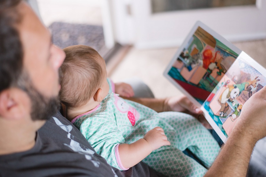 Vader en baby zijn samen boekjes aan het lezen