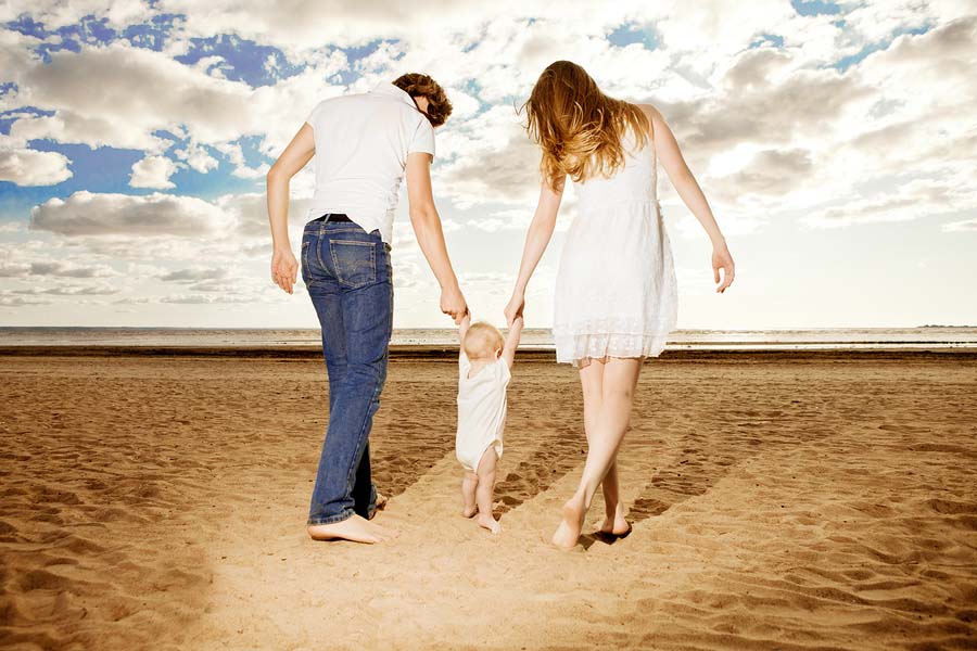 Een baby doet haar eerste stapjes op het strand