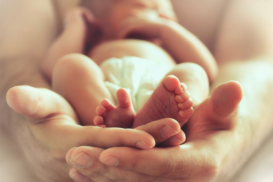 man-houd-pasgeboren-baby-vast-je-ziet-zijn-voetjes-blog-joyce