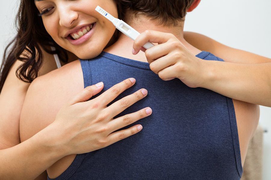 vrouw-omhelst-man-met-positieve-zwangerschapstest