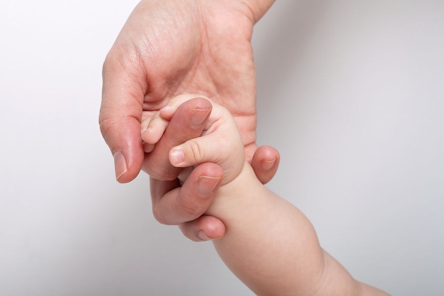 Moeder houdt handje vast van baby die anders is