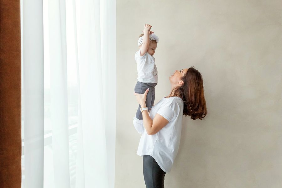 Fulltime moeder tilt haar baby in de lucht