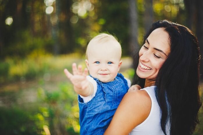 Baby van 24 maanden zwaait naar de camera