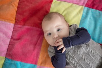 Baby ligt op boxkleed speelkleed