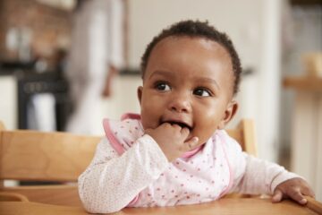 Baby zit in een kinderstoel