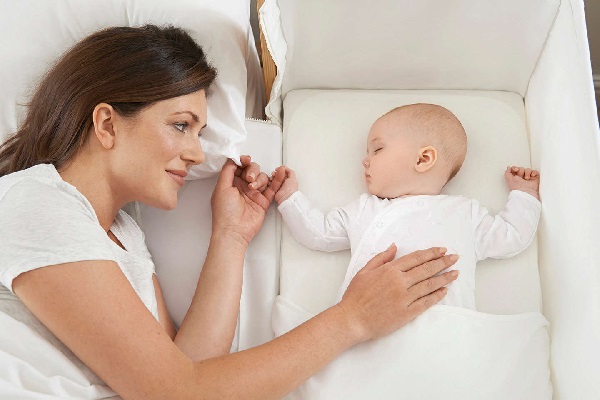 Een baby ligt op een wiegmatras