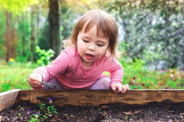 Kindje speelt in tuin en vermijdt hopelijk giftige planten