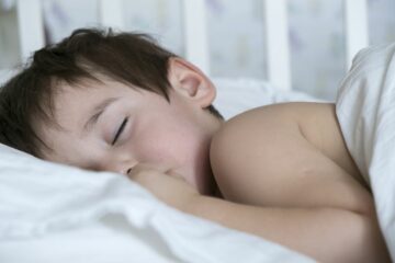 peuter slaapt met dekbed en kussen