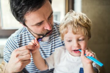 Vader is aan het tandepoetsen met peuter