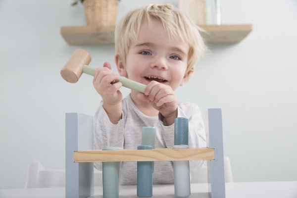 Jongen speelt met houten speelgoed gekregen als kraamcadeau