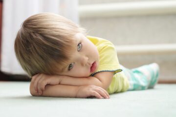 Peuter ligt verdrietig onderaan de trap tijdens time-out