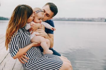 Ouders en baby genieten op een steiger van verlof rondom zwangerschap en ouderschap