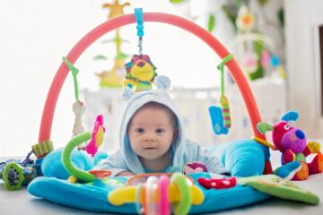 Baby speelt met babyspeelgoed op speelkleed