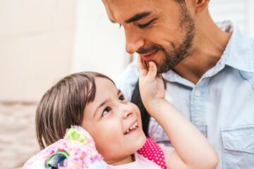 peuter kijkt heimelijk lachend naar vader terwijl ze aan het liegen is