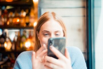 Vrouw bekijkt de gedragsregels van het forum op haar telefoon