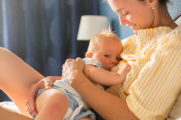 Moeder geeft borstvoeding terwijl ze aan feitjes denkt