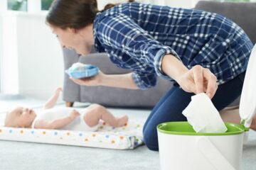 Moeder verschoont baby en gooit billendoekje in luieremmer