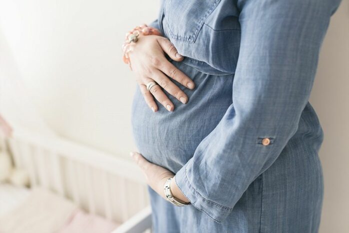 Vrouw houdt zwangere buik vast