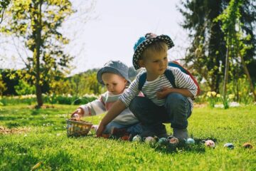 Peuter broer en zus vieren Pasen met eieren zoeken