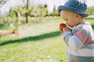 Kindje ruikt aan paasei terwijl hij paasspelletjes speelt