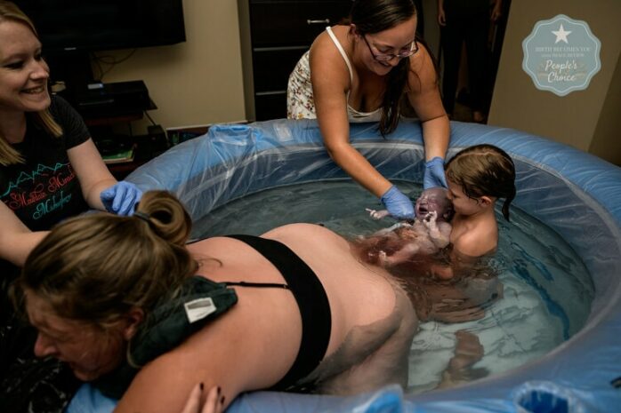 Dochter van vrouw vangt pasgeboren baby op in bad