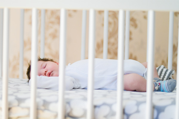 baby slaapt op ledikantmatras
