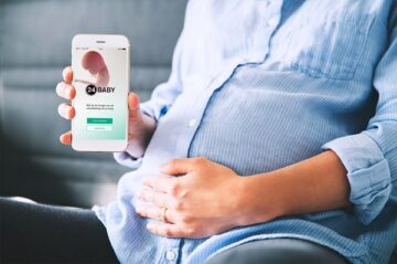 Zwangere vrouw laat 24Baby app zien