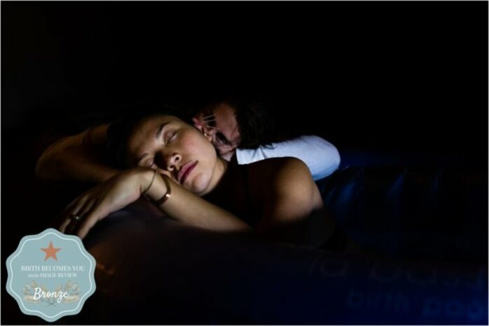 Vrouw vangt weeën op terwijl haar partner haar steunt