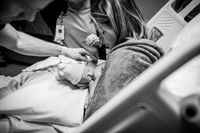 Vrouw legt haar pasgeboren baby aan de borst