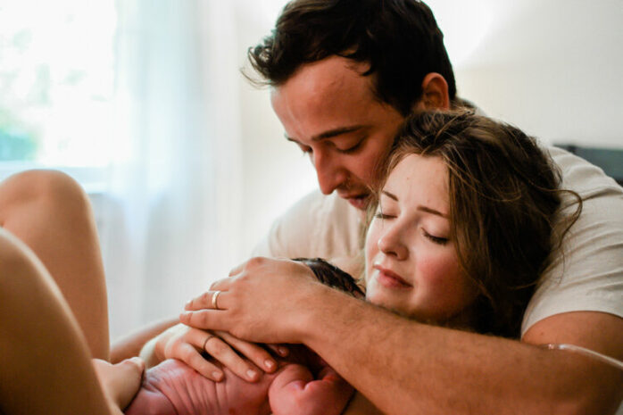 Vader en moeder houden sereen hun baby vast