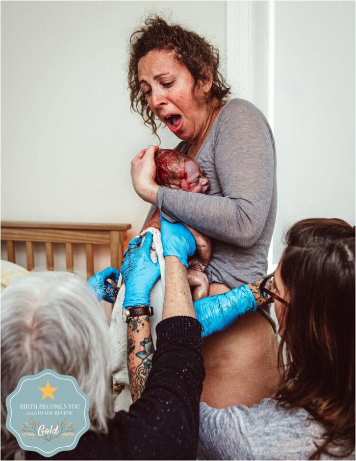 Moeder houdt pasgeboren baby vast en kijkt geëmotioneerd