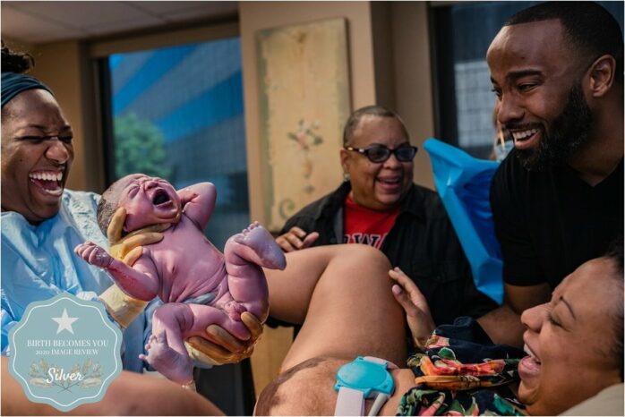 Iedereen lacht en ouders zien pasgeboren baby voor het eerst