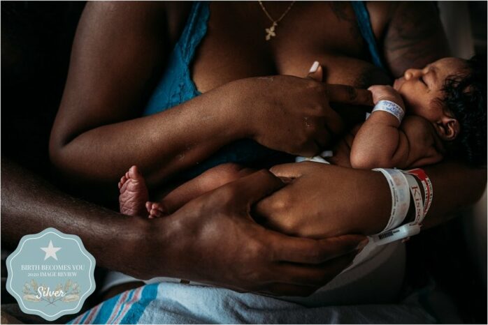 Pas bevallen vrouw legt newborn aan aan de borst