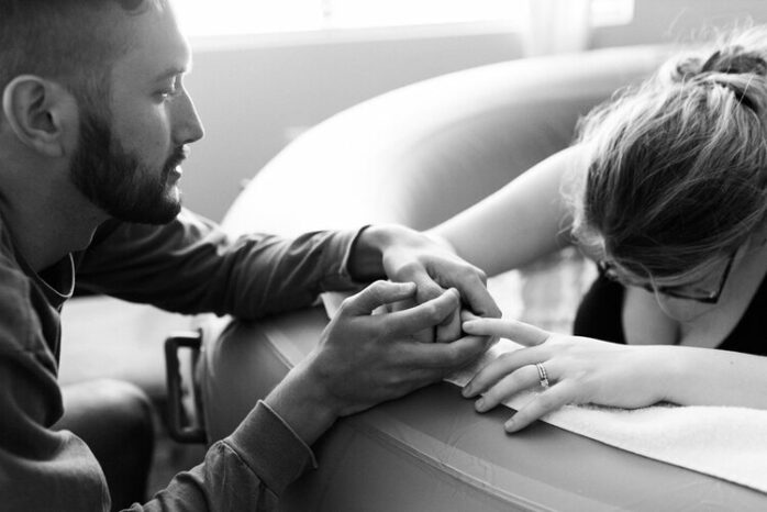 Partners houden elkaars hand vast tijdens weeën