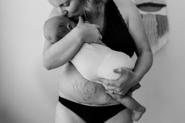 Vrouw houdt kindje vast op buik na bevalling