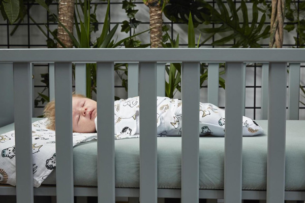 kindje is ingebakerd met inbakerdoek