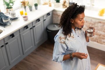 Vrouw is zwanger en drinkt water tegen droge mond