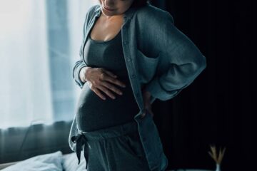 Zwangere vrouw heeft last van indalingsweeën en houdt haar buik vast