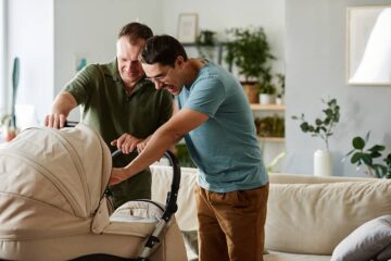 Ouders kijken naar baby in kinderwagen en denken na over aanvullende zorgverzekering baby
