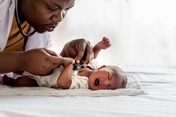 Arts onderzoekt baby met zorgverzekering