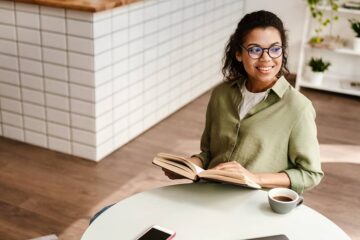 Zwangere vrouw leest boek in café
