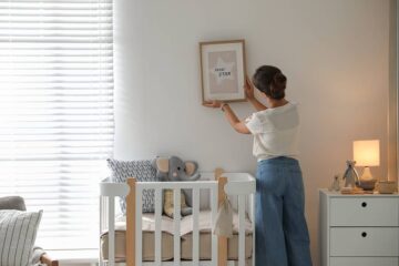 Aanstaande moeder hangt schilderij op in babykamer