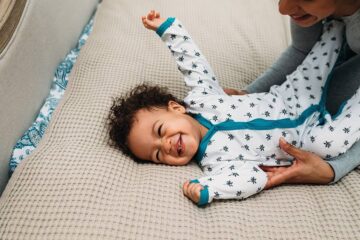 Baby met maat 74 knuffelt met moeder