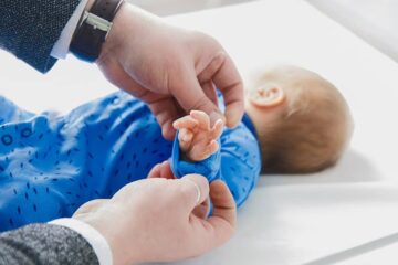 Vader kleedt baby met maat 44 aan