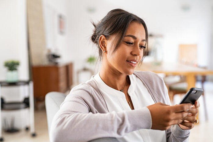 Zwangere vrouw kijkt naar ovulatie-app om haar vruchtbaarheid bij te houden