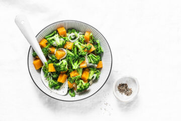 Bord met warme lunchsalade met pompoen en broccoli