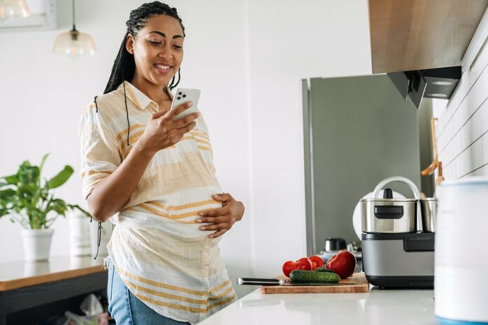 Zwangere vrouw leest in de 24baby app