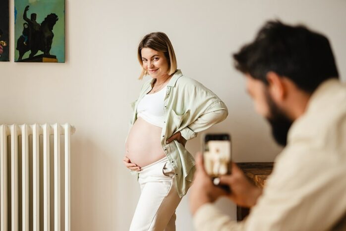 Man maakt buikfoto's van zwangere vrouw voor in de 24baby-app