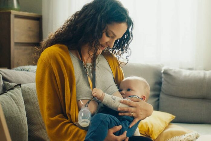 Moeder geeft borstvoeding en vangt gekolfde melk op